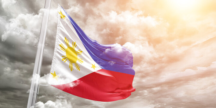Philippines national flag cloth fabric waving on beautiful cloudy Background.