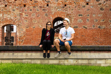 A young couple on excursions in an ancient castle - obrazy, fototapety, plakaty