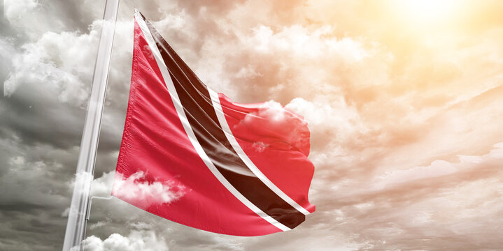 Trinidad and Tobago national flag cloth fabric waving on beautiful cloudy Background. - Powered by Adobe