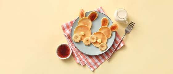 Funny Easter bunny pancakes with banana and jam on yellow background