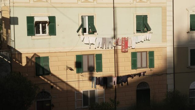 clothes hanging from a building in the sun on a summer day
