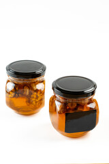 Jar of honey with nuts on white background