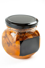 Jar of honey with nuts on white background