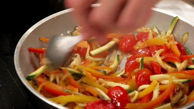 the chef finishes the ratatouille by mixing the seasoning
