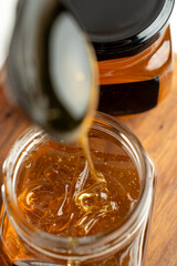honey flows from a spoon into a jar