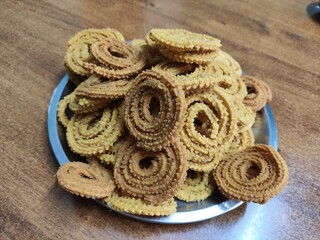 group of freshly fried spiral chakli snack placed in a plate