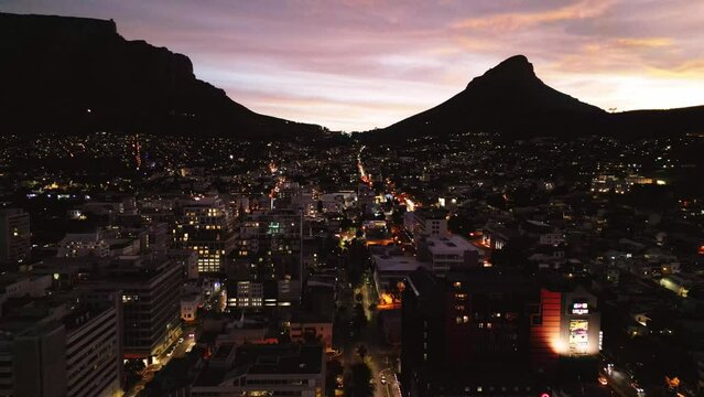 Aerial drone sunset flight over downtown Cape Town, South Africa towards Table Mountain and Lion's Head