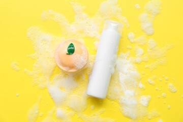 Bottles of skin care cosmetic products with foam on yellow background