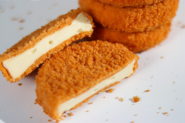 A stack of fried camembert with one cutter cheese on white table