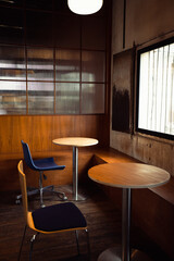 Wooden room with blue chair and circle table.