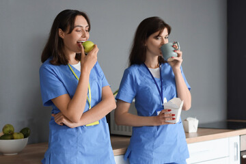 Female doctors having lunch in hospital kitchen - obrazy, fototapety, plakaty
