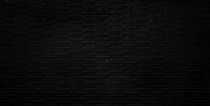 Panoramic background of wide black urban brick wall texture.