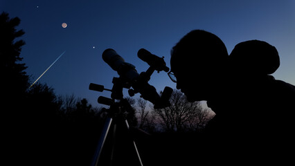 Amateur astronomer looking at the evening skies, observing planets, stars, Moon and other celestial...