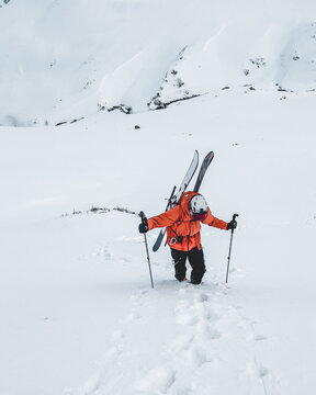 Mountaineer walking up along a snowy mountain with the skis in the backpack. Skier on the climbing track for freeride-descent. Backcountry skiers. ski free rider climbs the slope into deep snow powder