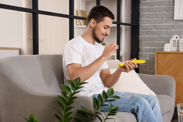 Young man with pill organizer at home