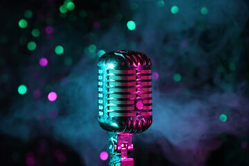 Fototapeta na wymiar Retro microphone and smoke against blurred lights, closeup