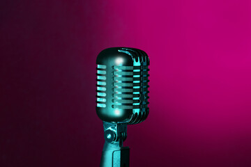 Retro microphone on dark pink background, closeup