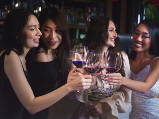 Group of friends partying in a nightclub and toasting . Happy young people enjoy with wine