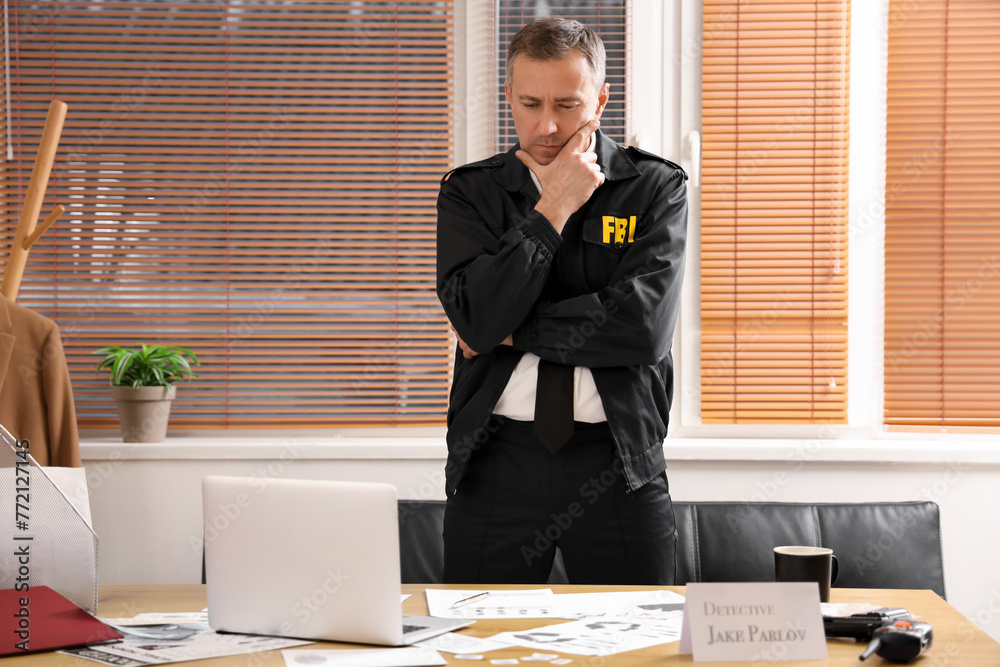 Wall mural thoughtful mature fbi agent working at table in office