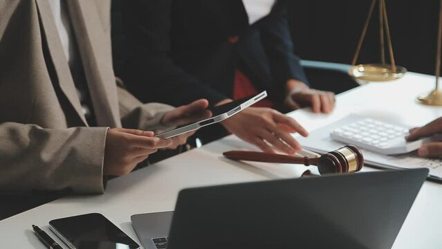 Business and lawyers discussing contract papers with brass scale on desk in office. Law, legal services, advice, justice and law concept picture with film grain effect