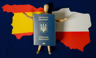 Wooden human mannequin with a Ukrainian passport. Poland map. Spain map. Blue background of European Union Flag. Ukraine population migration. War. The threat of life.