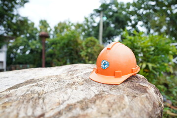 Orange safety helmet on the stone in the construction site power distribution station, stock photo - 772131700