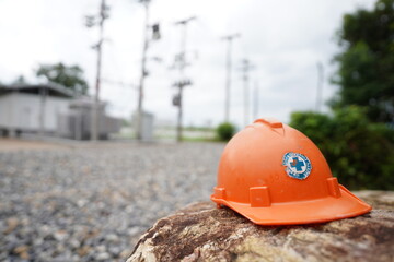 Orange safety helmet on the stone in the construction site power distribution station, stock photo - 772131708