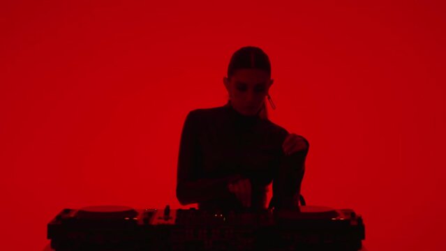 Beautiful DJ Woman Mixing Tracks In Studio With Red Background, Medium Portrait Shot, Modern Music