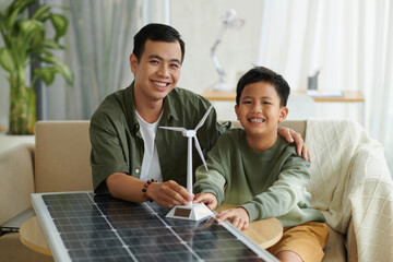 Portrait of happy father and son learning about renewable energy