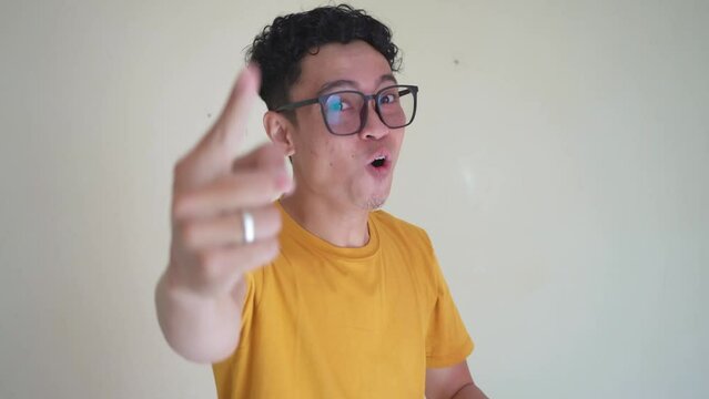 Young Indonesian curly man wear yellow t-shirt with strong pose. The footage is suitable to use for man expression and people advertising content media.