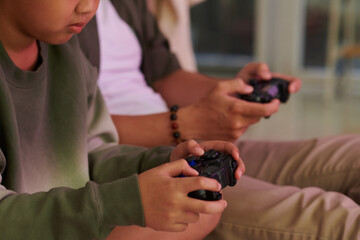 Closeup image of boy playing videogames with father