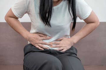 young woman hands in belly, stomach pain from food poisoning, abdominal pain and digestive problem,...