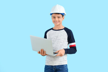 Little architect with laptop on blue background