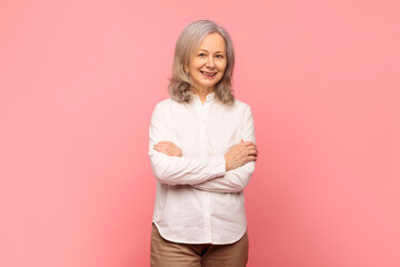 Portrait of gray haired mature woman posing with folded arms
