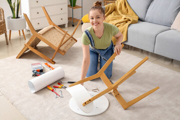 Beautiful young happy woman assembling furniture at home