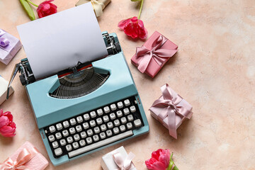 Composition with typewriter for Women's Day, gift boxes and tulips on pink background