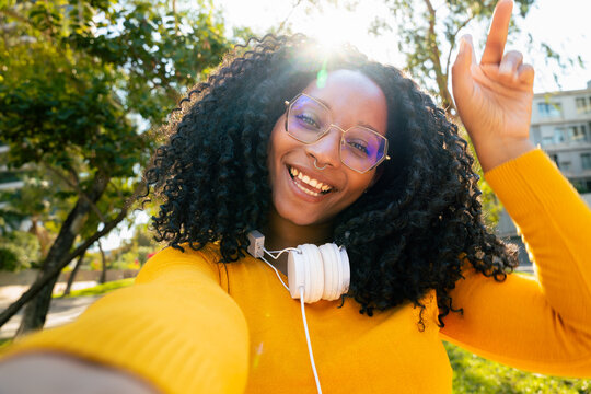  Front view of cheerful black woman with smile having a video call on the phone.