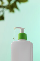 Green-capped dispenser with a single gel drop, symbolizing purity and care. Shampoo, gel shower.