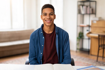 Cheerful black guy student with book ready to study