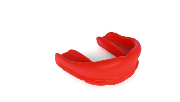 Red sports mouthguard on white backdrop. Protective mouthpiece for athletes. Boxing mouth guard. Concept of sports safety, athletic gear, dental prevention, and contact sports equipment.