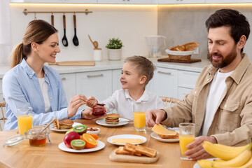 Happy family having breakfast at table in kitchen