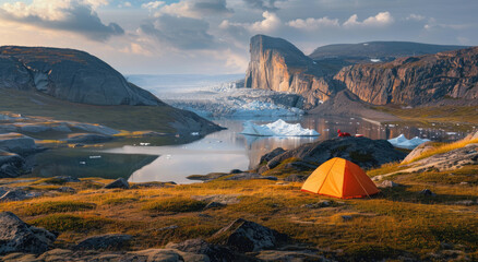 Camping in the arctic at a campsite with an orange tent on a grassy hill overlooking a valley and a small lake with people fishing in the distance and large icebergs floating - Powered by Adobe