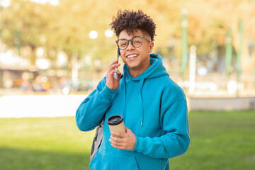 Happy student talking on phone with coffee
