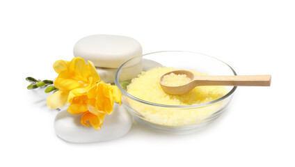 Yellow sea salt in bowl, flowers, spa stones and spoon isolated on white