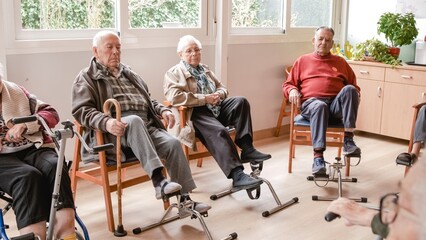 Senior people doing pedal exercises at rehabilitation center - obrazy, fototapety, plakaty