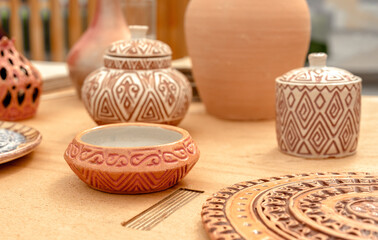 Pottery with traditional Asian designs is sold at a street market. Handmade