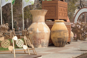 Huge clay jugs against the backdrop of giant Asian chests with carved ornaments - - street decor for the holidays