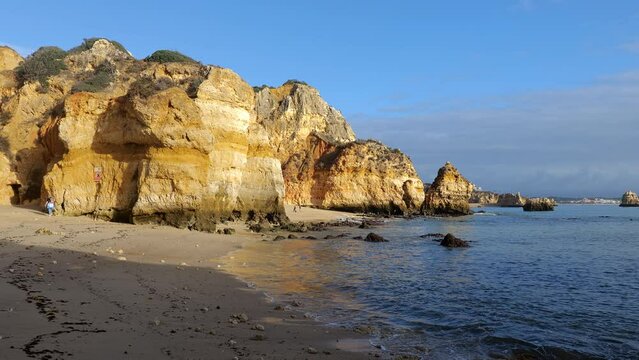 Morning sun at the Camilo Beach (Praia do Camilo) by the Atlantic Ocean in Algarve region, Lagos, Portugal.