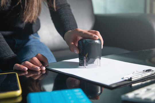 Business woman using stamp on document.