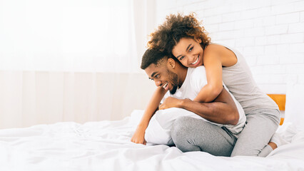 Happy loving african american couple bonding in bed